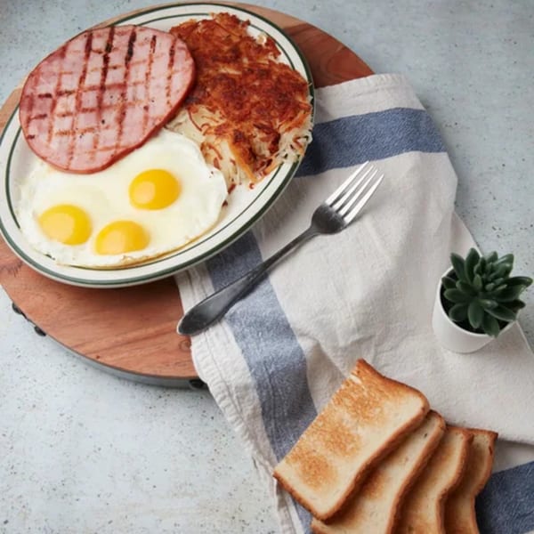 John's Place breakfast with grilled ham, three fried eggs, hash browns, toast, and a succulent.